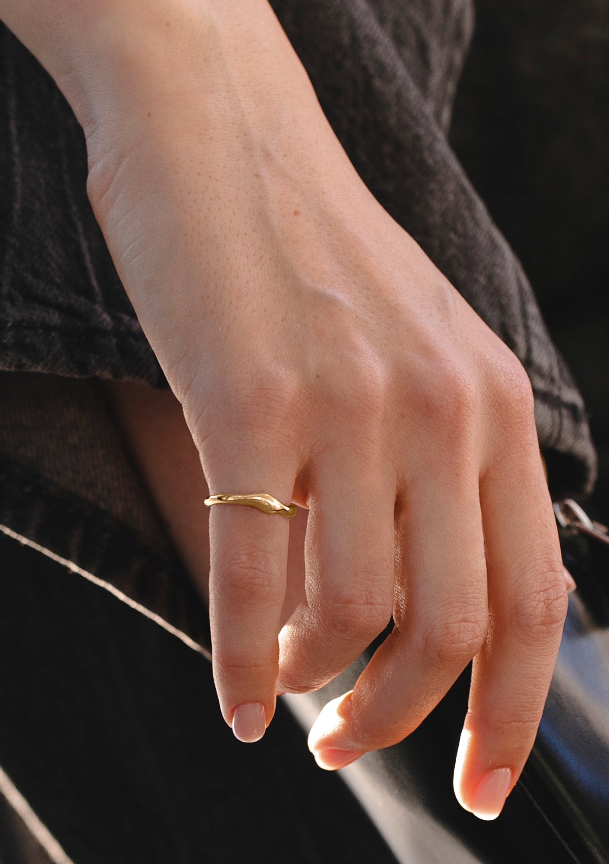 Close-up of Neia gold ring on hand, highlighting soft organic curves