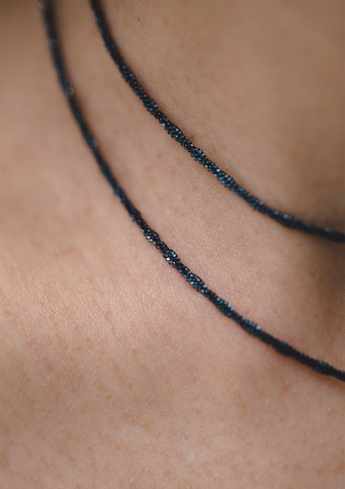 Close-up of oxidized sterling silver chain choker against skin tone