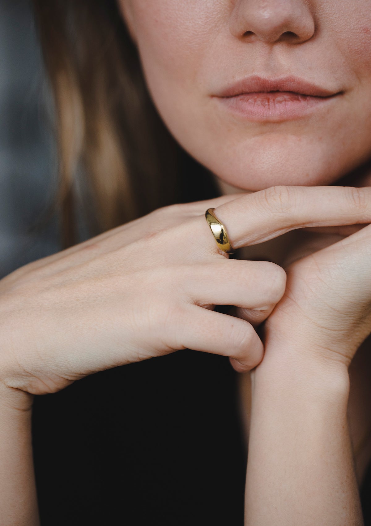 Close-up of 14k Isla gold ring reflecting light on finger, modern jewelry look