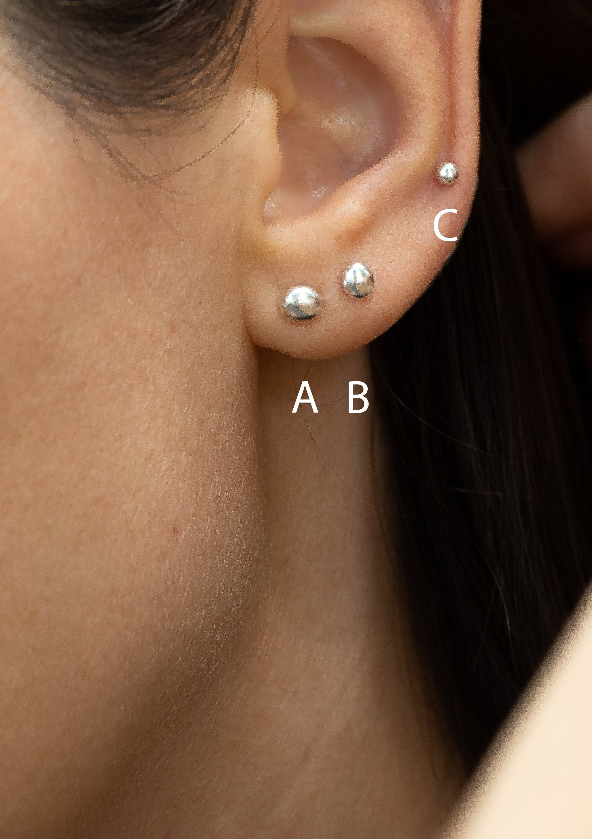 Elegant 925 silver stud earrings with natural pebble texture, delicate design glinting subtly in profile